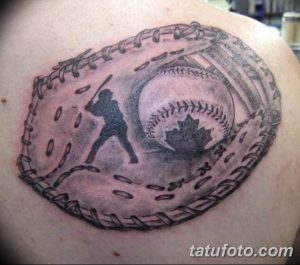 Фото тату на плече: бейсбольная перчатка, внутри силуэт бьющего игрока и кленовый лист, выполненное в черно-серых тонах.