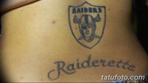 Черно-серая татуировка с логотипом команды Raiders на ключице и надписью 'Raiderette'. Подходит для фанатов американского футбола и любителей дерзких рисунков.