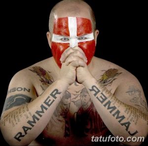 Фото тату на теле фаната группы Rammstein. Изображены портреты участников группы, логотип и тексты песен. Яркий и детализированный рисунок.