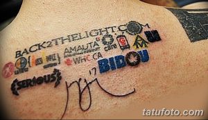 Фото тату на плече с множеством разноцветных логотипов и надписей, выполненных в стиле олдскул. Идеально для фанатов брендов и команд.