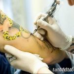 Фото процесса нанесения татуировки змеи и цветов на руку, мастер работает тату-машинкой.