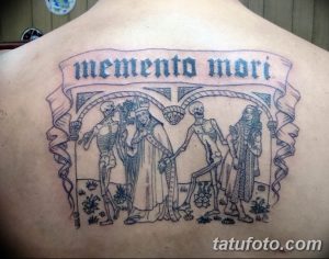 Фото тату в стиле Memento Mori на спине. Изображение скелетов и надпись 'memento mori' в готическом стиле.