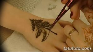 Фото тату: процесс нанесения эскиза татуировки в виде ели хной на руку, демонстрирующий детализацию рисунка.