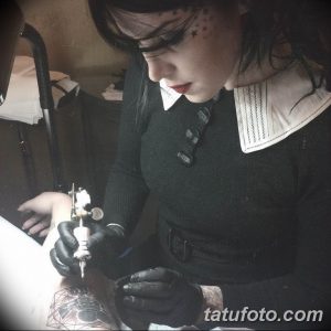 Фотография процесса нанесения татуировки, демонстрирующая работу мастера и детали татуировки на руке.