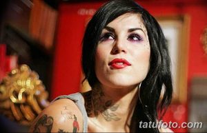 Фотография Кат Вон Ди с ярким макияжем и татуировками на руках и шее. Она смотрит в камеру с выразительным взглядом.