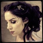 Фото Kat Von D: тату-мастер с татуировками в виде звезд на лице и татуировками на шее. Детальный портрет с акцентом на татуировки.