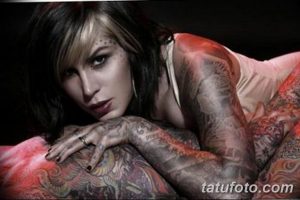 Фотография девушки с обширными татуировками на теле, демонстрирующая сложный рисунок татуировки в стиле традиционной американской татуировки и реализма.