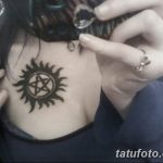 Фото тату: черная татуировка в виде антидемонского символа (знак Кастиэля) на груди девушки. Мистический и загадочный рисунок татуировки.