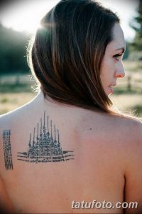Фото тату Сак Янт на спине женщины. Черно-белый рисунок с геометрическими фигурами и тайскими письменами, выполненный в традиционном стиле.