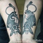 Фото двух татуировок Анубиса на предплечьях. Рисунки выполнены в черных тонах с использованием геометрических узоров и символа Анкх.