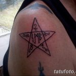 Фотография татуировки на плече, изображающей пятиконечную звезду, внутри которой расположены различные оккультные символы.