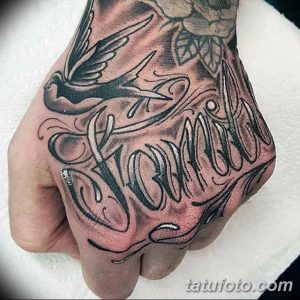 Фото тату на руке с надписью 'Momma' и летящей ласточкой, выполненное в стиле blackwork с детальной проработкой перьев и завитушек.