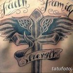 Фото тату на спине с изображением креста, окруженного крыльями, и надписями 'Faith', 'Family', 'Strength'. Религиозный эскиз тату в черно-белой гамме.