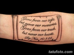 Фото татуировки на предплечье, изображающей свиток с надписью "Gone from our sight, but never our memories". Черно-серый рисунок.