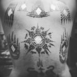 Фото тату в стиле Сак Янт на спине. Черно-белый рисунок с использованием традиционных тайских символов и геометрических узоров.