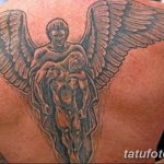 Фото тату ангела на спине. Черно-серый рисунок татуировки с изображением ангела, несущего на руках душу, символизирующего защиту и вечную любовь.