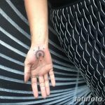 Фото тату: изящная татуировка солнца на ладони, выполненная в тонких черных линиях. Символ энергии и жизни.