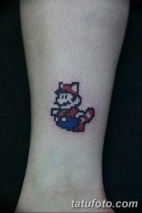 Фото тату в стиле 8-bit: Марио из Super Mario Bros. на предплечье. Небольшой размер и пиксельная графика.