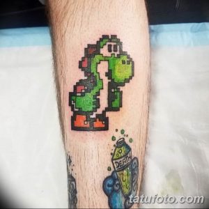 Фото тату с изображением Йоши из Super Mario и пузыря с надписью 'DEATH' в пиксельном стиле на икре.