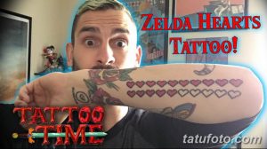 Фото татуировки на руке, изображающей ряд пиксельных сердец из игры The Legend of Zelda, выполненных в розовых и фиолетовых тонах.