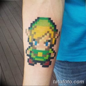 Фото тату: пиксельный персонаж Линк из игры The Legend of Zelda на предплечье. Яркий и узнаваемый рисунок татуировки для геймеров.