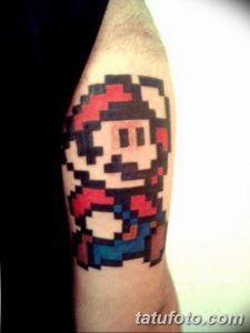 Фото тату в стиле пиксель-арт с изображением Марио, героя видеоигры Super Mario Bros. Рисунок расположен на предплечье.