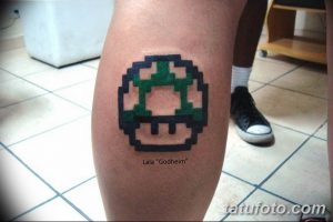 Фото татуировки в стиле пиксель-арт с изображением гриба из игры Super Mario на ноге.