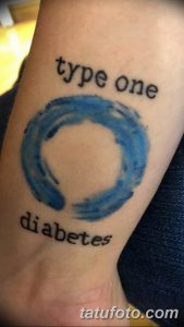 Фото тату на предплечье: надпись 'type one diabetes' и синий круг. Минималистичный дизайн и символическое значение.