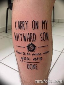 Фото татуировки на икре с текстом песни 'Carry On My Wayward Son' и символом из сериала 'Сверхъестественное'. Черный цвет, каллиграфический стиль.