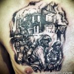 Фото тату с изображением группы пожарных, сражающихся с огнем на фоне горящего здания, выполненное в черно-серых тонах на груди и плече.