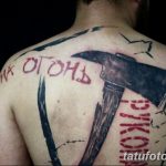 Фото тату топора с надписью на спине, выполненное в графическом стиле с использованием черного и красного цветов.