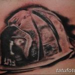 Фото тату пожарного шлема в черно-белой гамме, выполненное с высокой детализацией на руке. Идеальный эскиз тату для пожарных и спасателей.