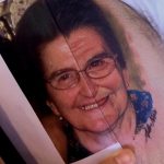 Фото тату: реалистичное изображение портрета пожилой женщины в очках, выполненное в цветных тонах, с акцентом на морщины и добрый взгляд.