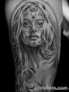 Черно-белое фото тату в стиле Sugar Skull с изображением девушки с традиционным мексиканским макияжем. Детализированная проработка узоров и цветов.