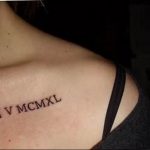 Фото тату на ключице: черные римские цифры, нанесенные на кожу. Идеально для тех, кто ищет идеи для небольшой и символичной татуировки.