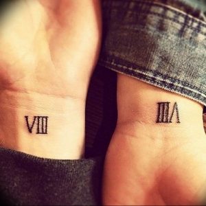Фото парных тату на запястьях с черными римскими цифрами VIII и III VI. Минималистичный дизайн, небольшие размеры, символическое значение.