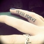 Фото тату с римскими цифрами VI XII MMVI на пальце. Тонкий и элегантный дизайн, популярный среди любителей минимализма.