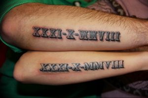 Фото тату: две парные татуировки с черными римскими цифрами 'XXXI-X-MMVIII' на предплечьях. Символизируют общую дату или связь между двумя людьми.