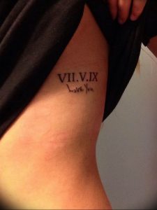 Фото тату на боку с римскими цифрами 'VII.V.IX' и надписью 'I love You', выполненной черными чернилами. Романтичный и нежный дизайн.
