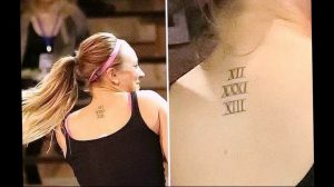 Фото парных тату на затылке с римскими цифрами, выполненных черными чернилами. Нежный и романтичный дизайн.