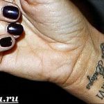Фото тату с римскими цифрами VII V MMVI и надписью на запястье женщины. Черный рисунок татуировки выполнен изящным шрифтом.