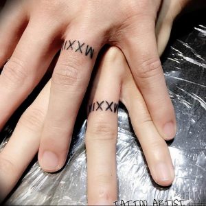 Фото парных татуировок на пальцах с римскими цифрами 'XXIV' и 'XXXW'. Минималистичный дизайн для любящих пар.