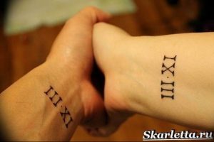 Фото парных татуировок на запястьях с римскими цифрами 'III.XI' и 'IX.III'. Минималистичный дизайн для любящих пар.
