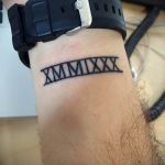 Фото тату: черная татуировка с римскими цифрами 'XMMIXXX' на запястье. Простой и минималистичный дизайн.