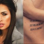 Фото тату: римские цифры на боку женщины. Черный рисунок татуировки, выполненный изящным шрифтом. На фоне портрет девушки.