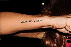 Фото тату: Татуировка с римскими цифрами VIII XIV V VIII на внутренней стороне запястья. Черный цвет, тонкие линии, простой и элегантный дизайн.