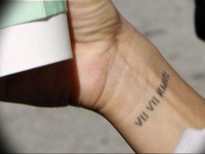 Фото тату: черные римские цифры 'VII VII VIII' на запястье, выполненные в минималистичном стиле.