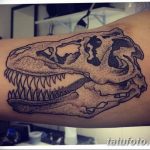 Фото тату: рисунок черепа динозавра, выполненный в технике dotwork на руке. Эскиз татуировки с использованием множества точек для создания текстуры.