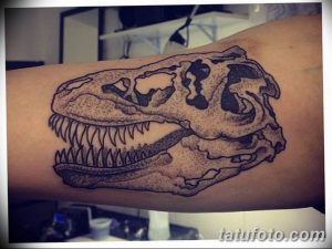 Фото тату: рисунок черепа динозавра, выполненный в технике dotwork на руке. Эскиз татуировки с использованием множества точек для создания текстуры.
