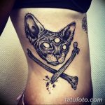 Фото тату черного кота с тремя глазами и костями. Рисунок выполнен в стиле dark art с использованием черных и серых оттенков. Идея для татуировки на бок.